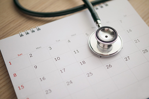 Stethoscope with calendar page date on wood table background doctor appointment medical concept